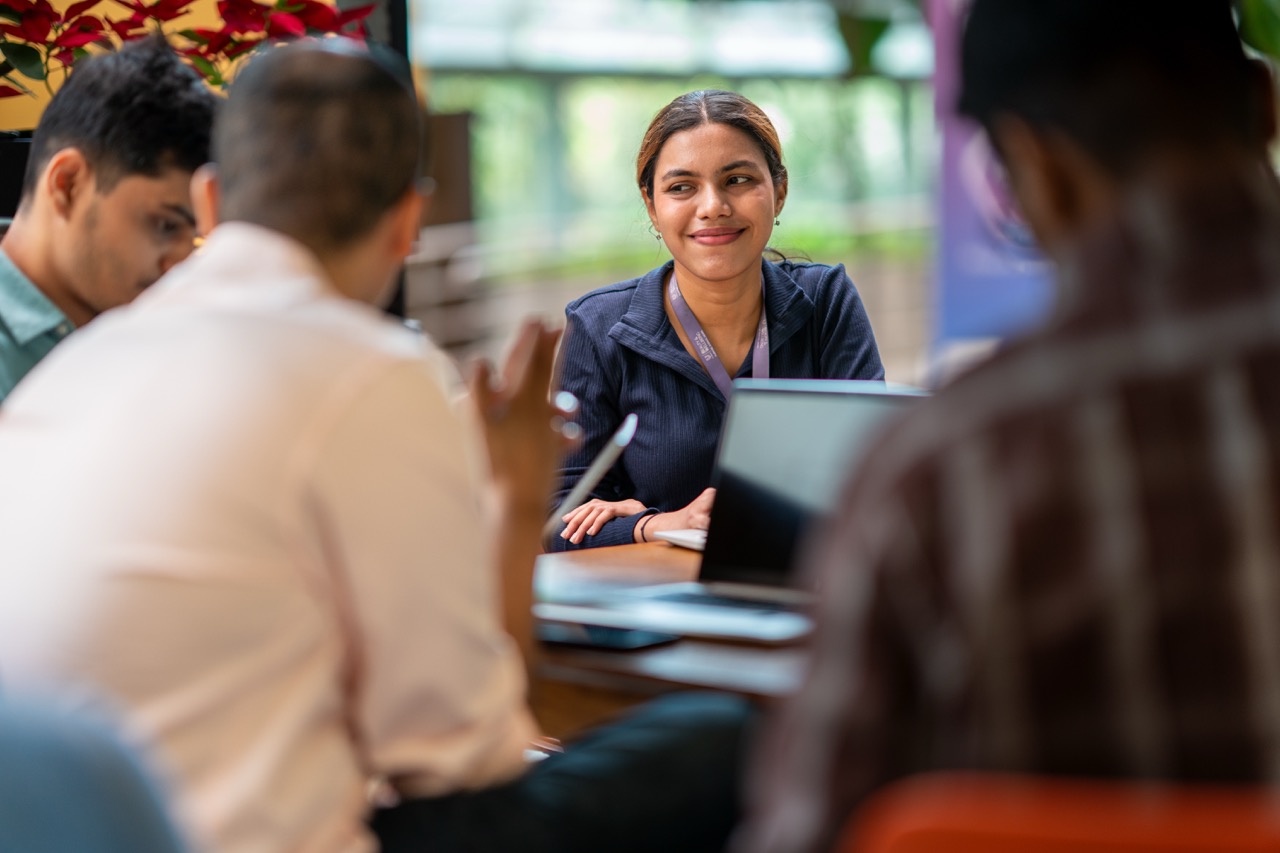 Team members collaborate in a meeting, sharing ideas and working together in a dynamic office environment.