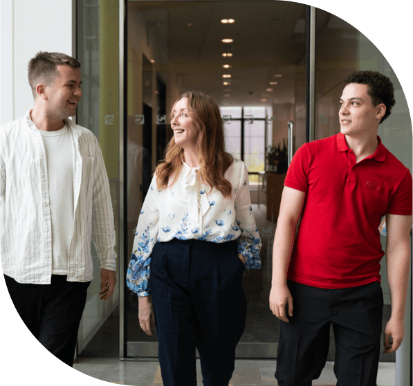 three professionals discussing walking side by side in a modern office