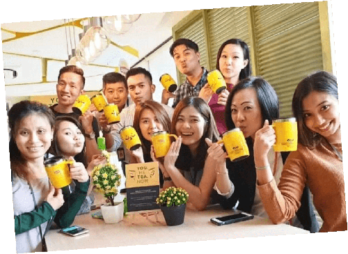 A group of employees pose with coffee mugs