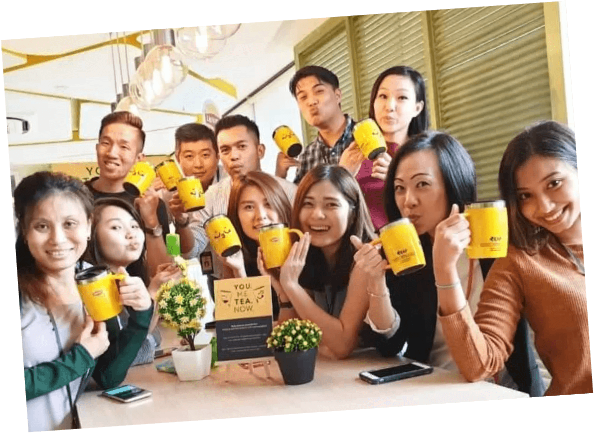A group of employees pose with coffee mugs
