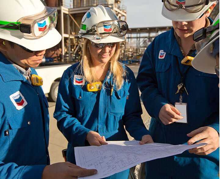 Chevron employees reading a schematic