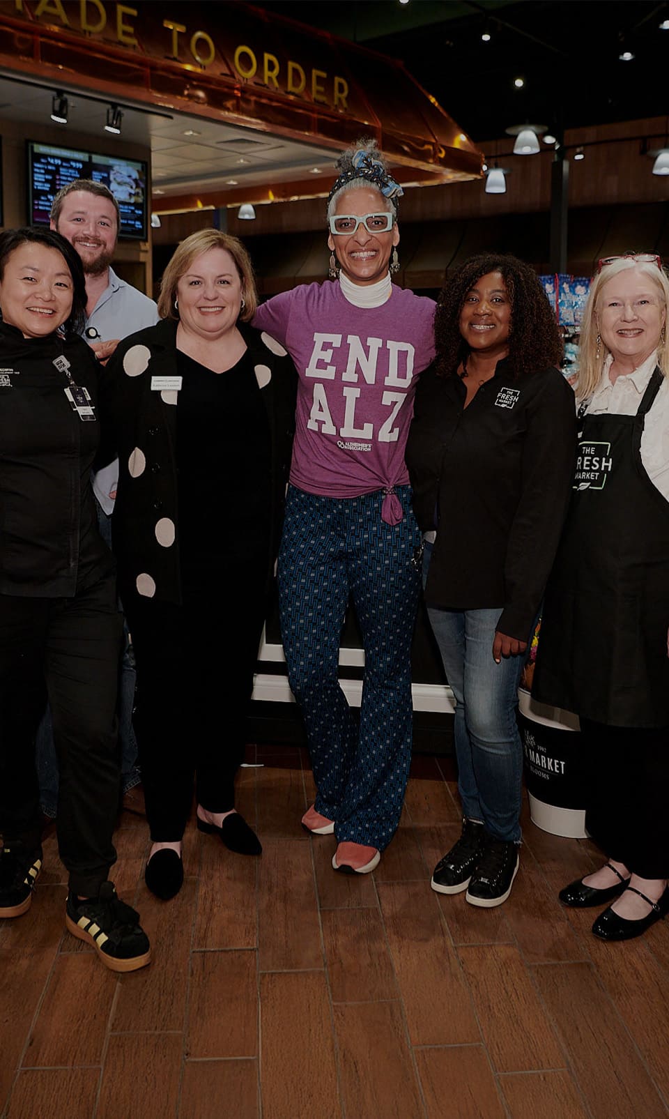 Young woman, wearing white facemask and blue shirt, smiling for the camera