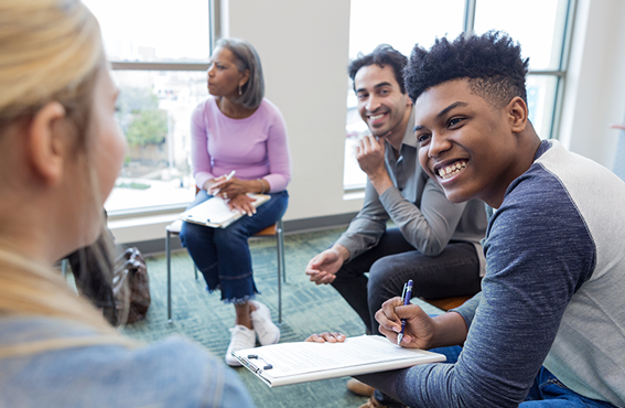 Employees sitting in circle and smiling at one another