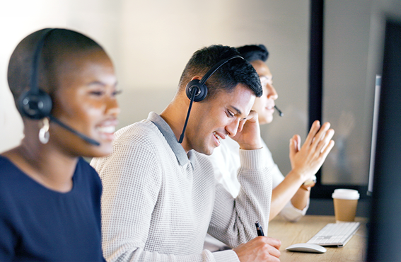 Workers sitting at computer desks while wearing headsets