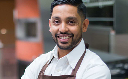 Closeup portrait of guy smiling in brown apron