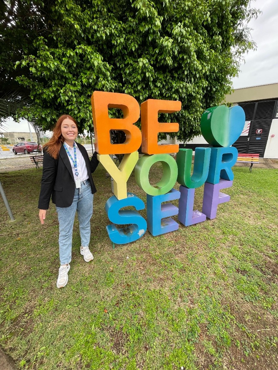 Nina in front of a be yourself sign