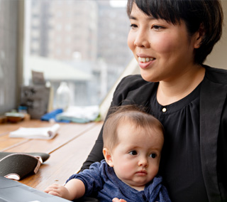 A women holding a baby and working
