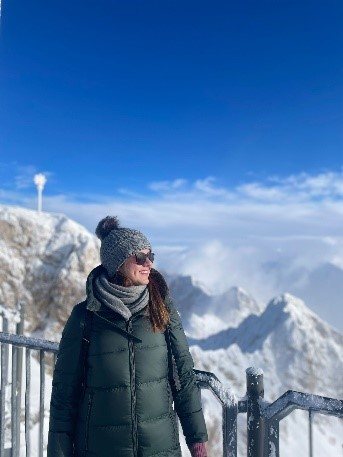 Anita stands in front of a snowy mountain peak.