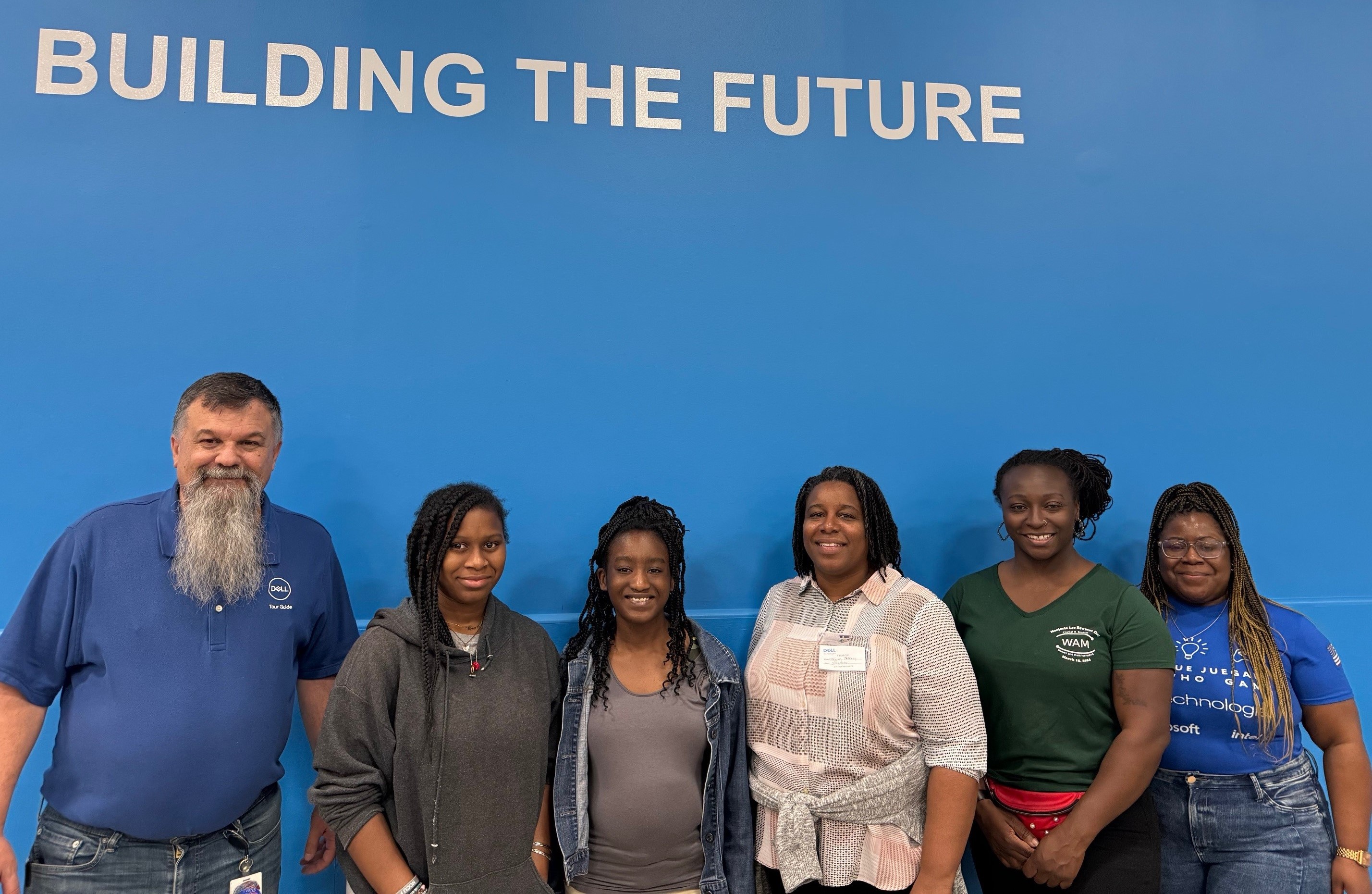 Briana with coworkers in front of a Dell sign that says, "Building the Future"