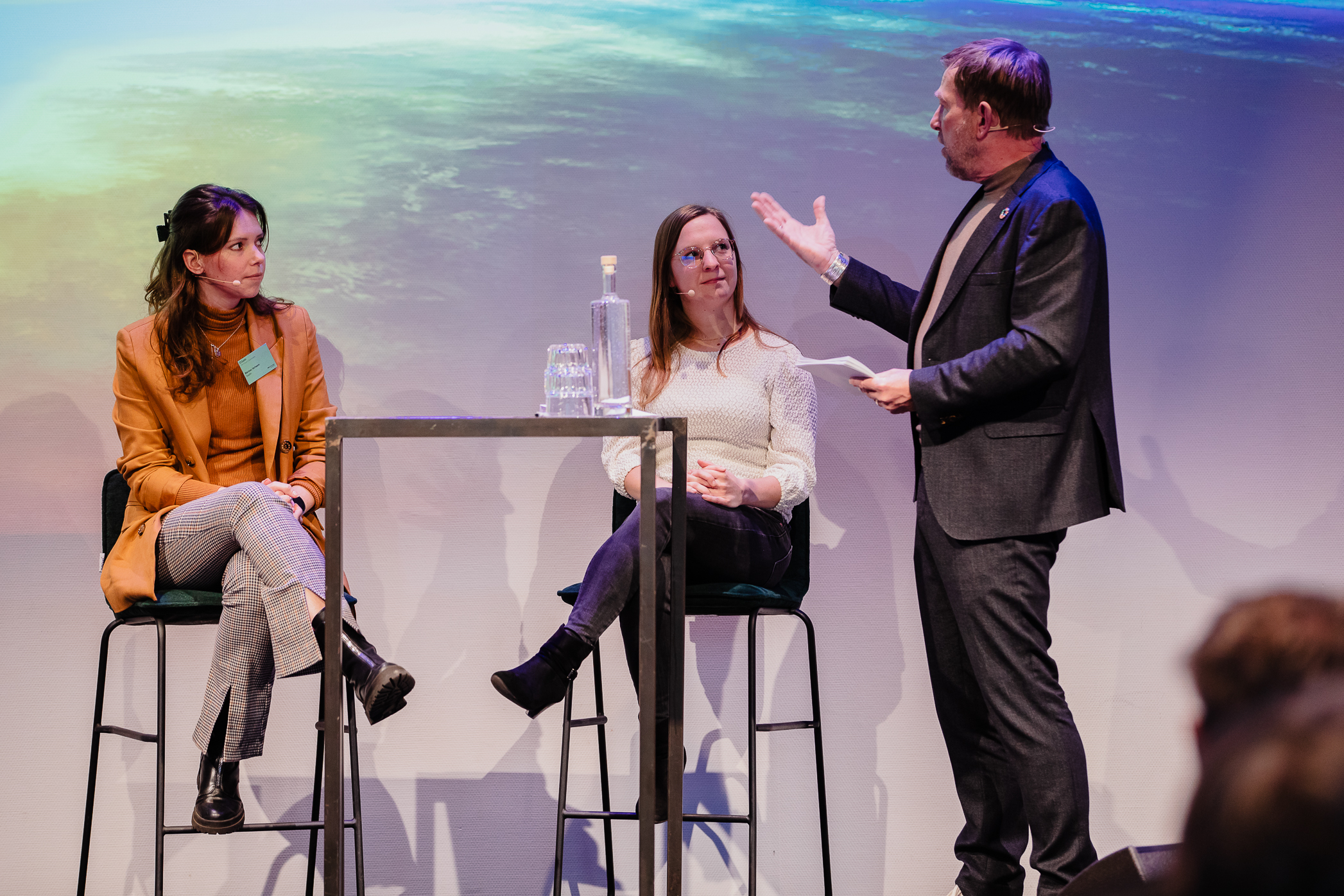 Femke on stage at an event with two other people