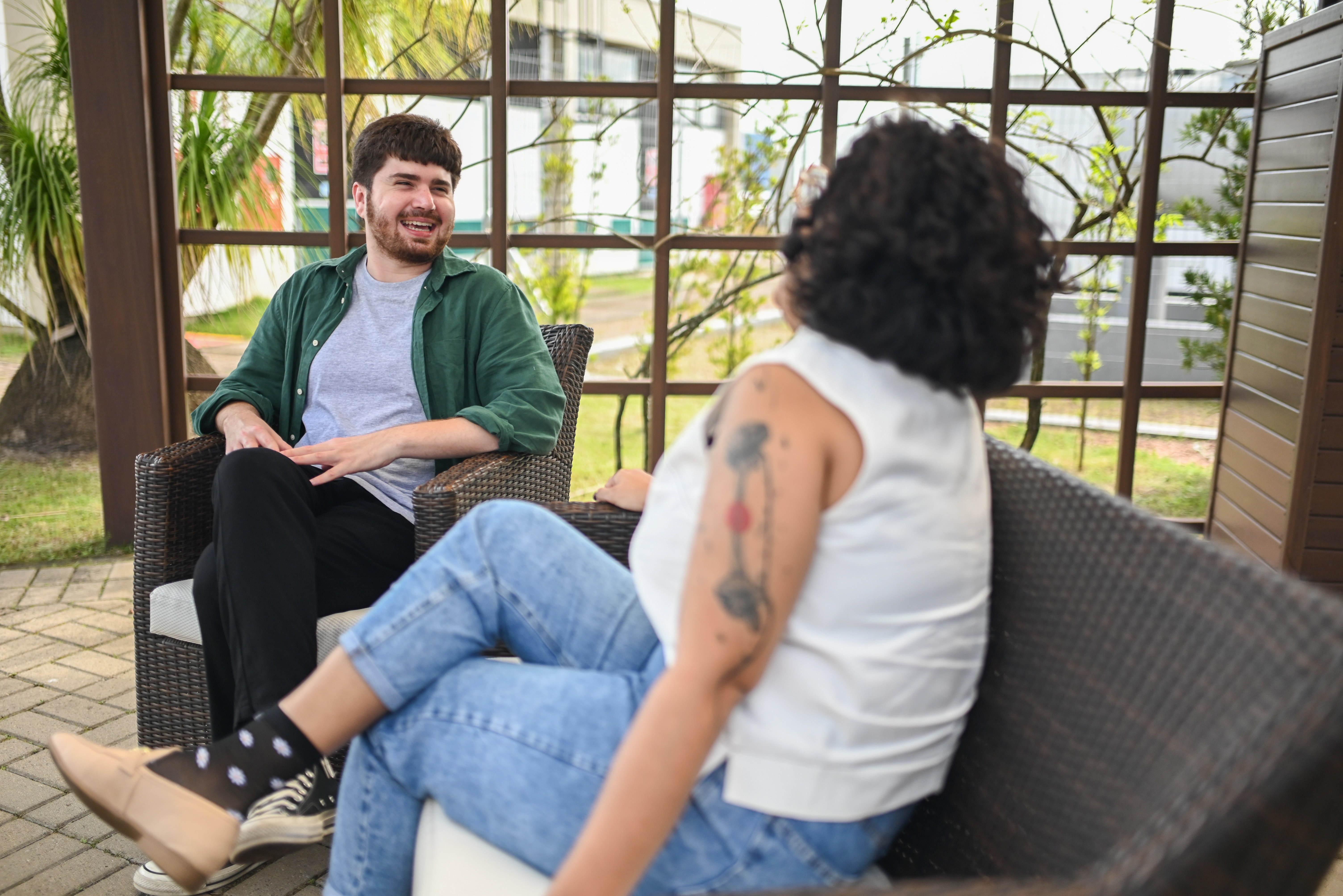 Guilherme sits on a bench with a woman.