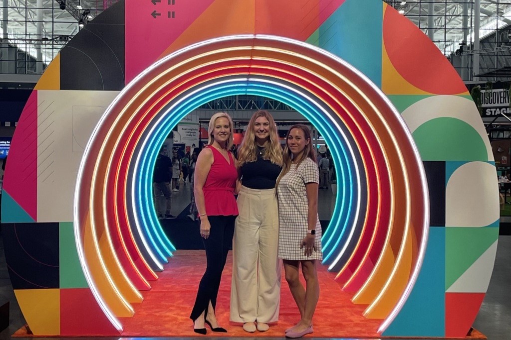 Kallan poses with two women on her team at a conference.