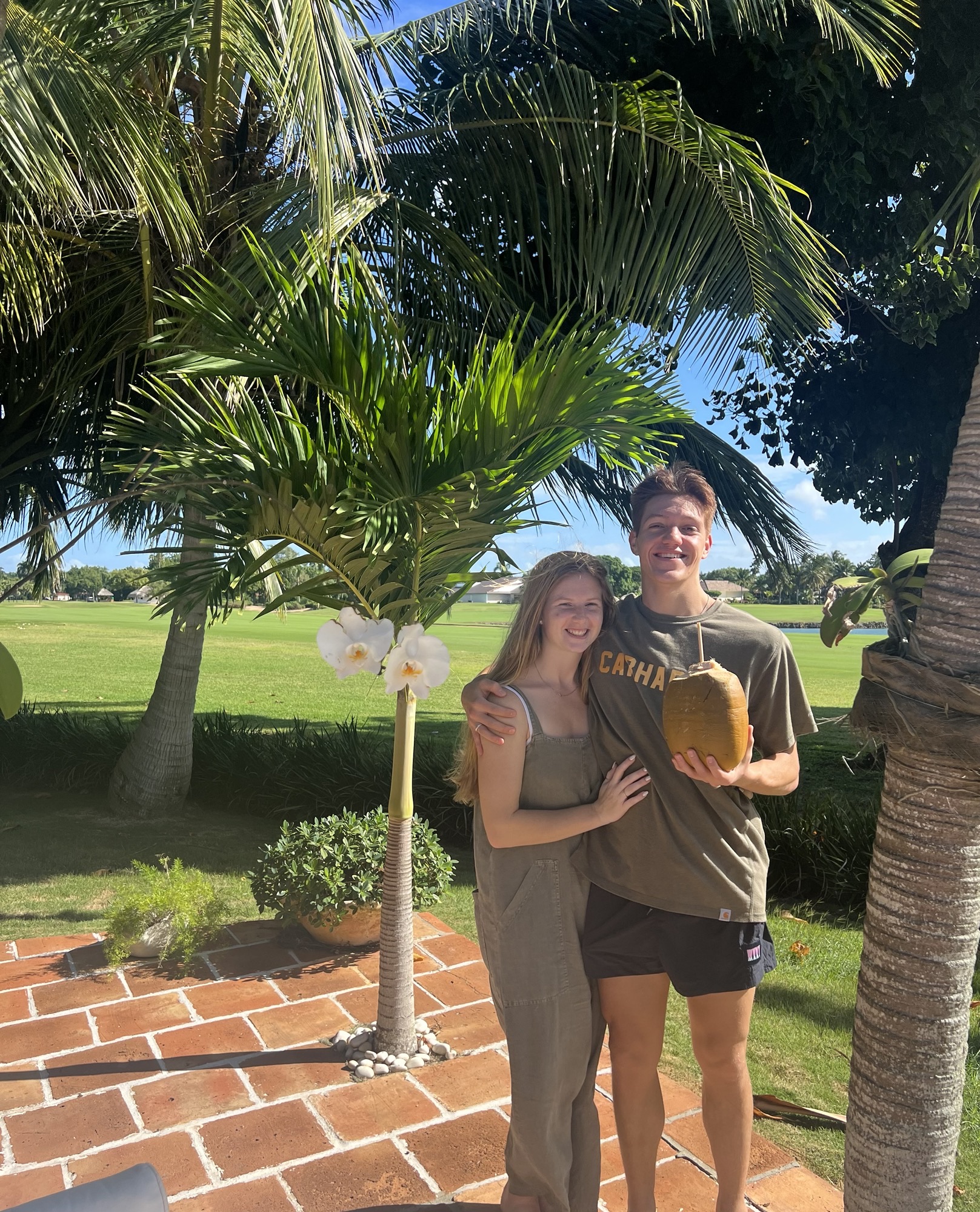 Lauren poses with a man holding a coconut.