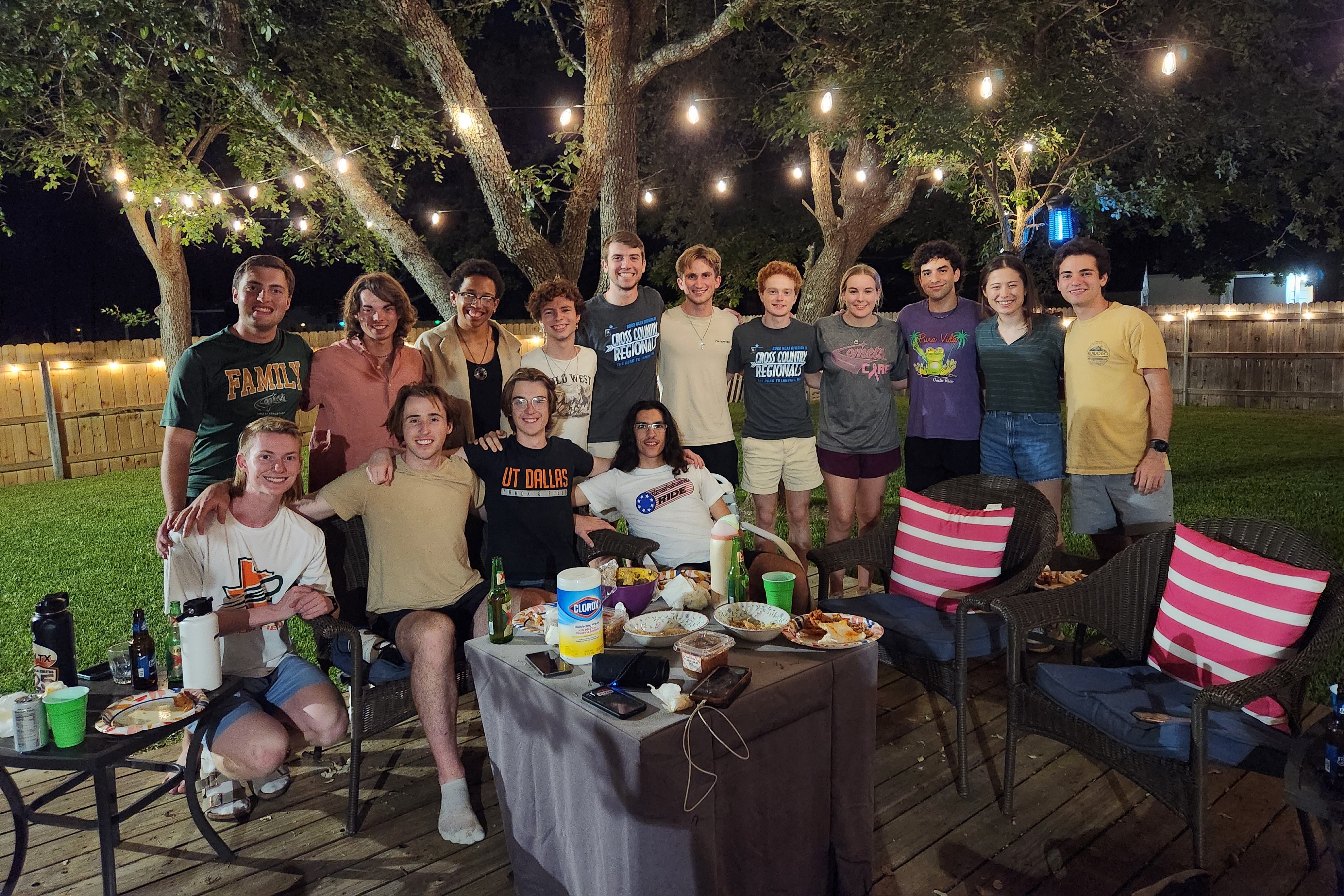 Matthew poses with a group of people in a backyard.