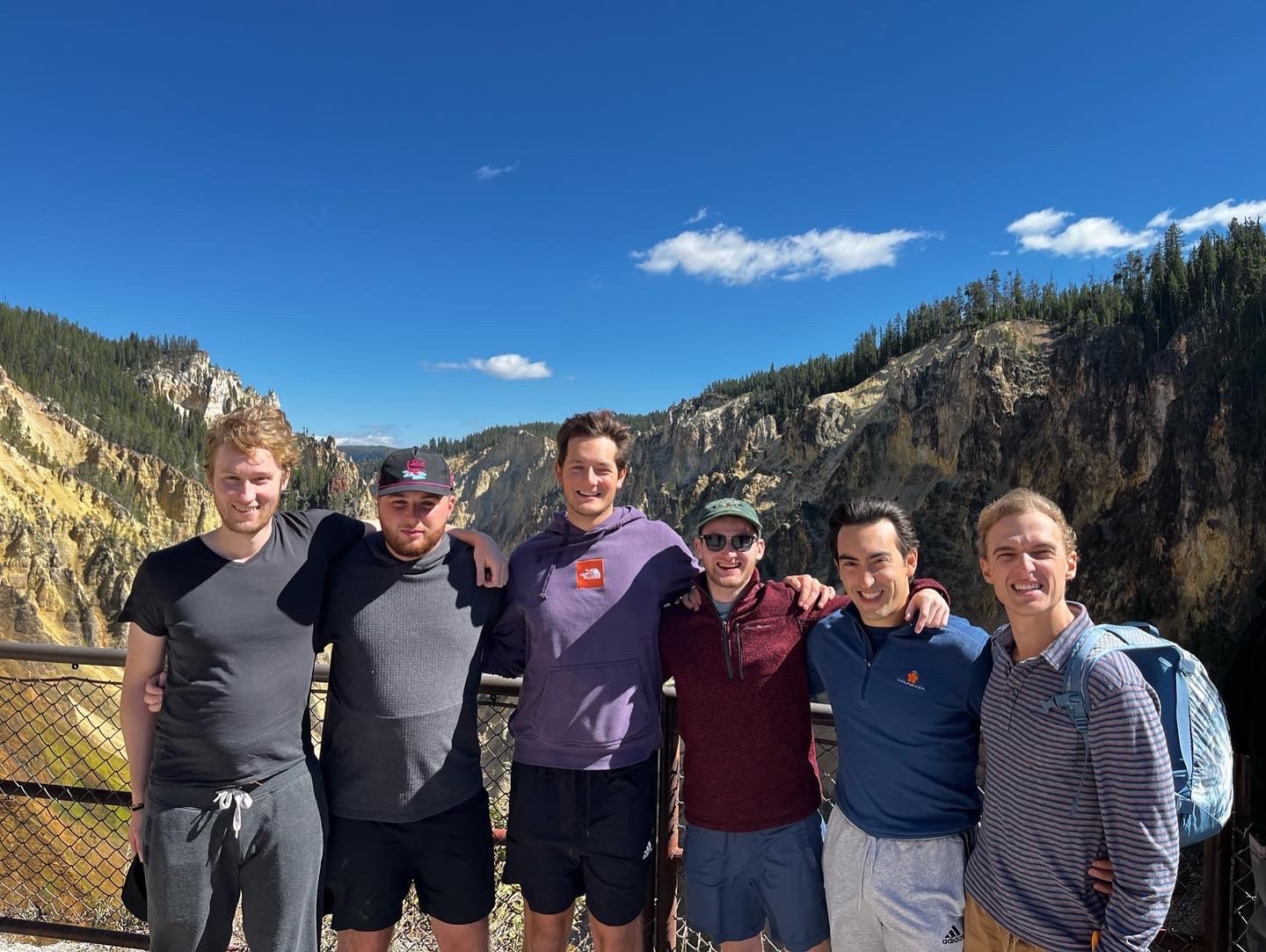 Mitch standing with friends at Yellowstone National Park