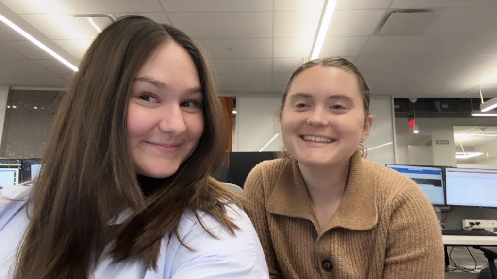 Sophia smiles while sitting in a Dell Technologies office with a co-worker.