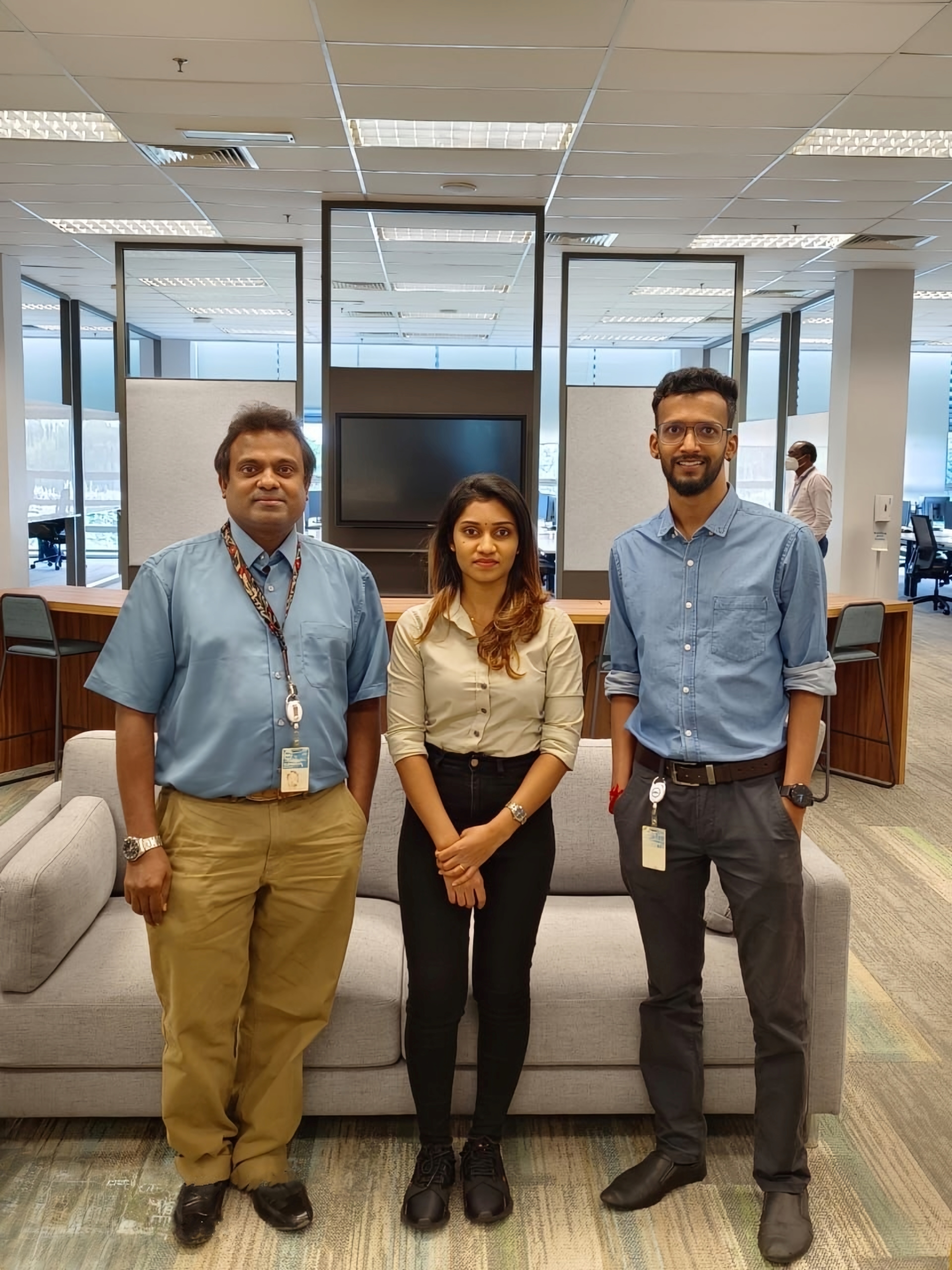 Sujendran poses in an office with a man and woman.