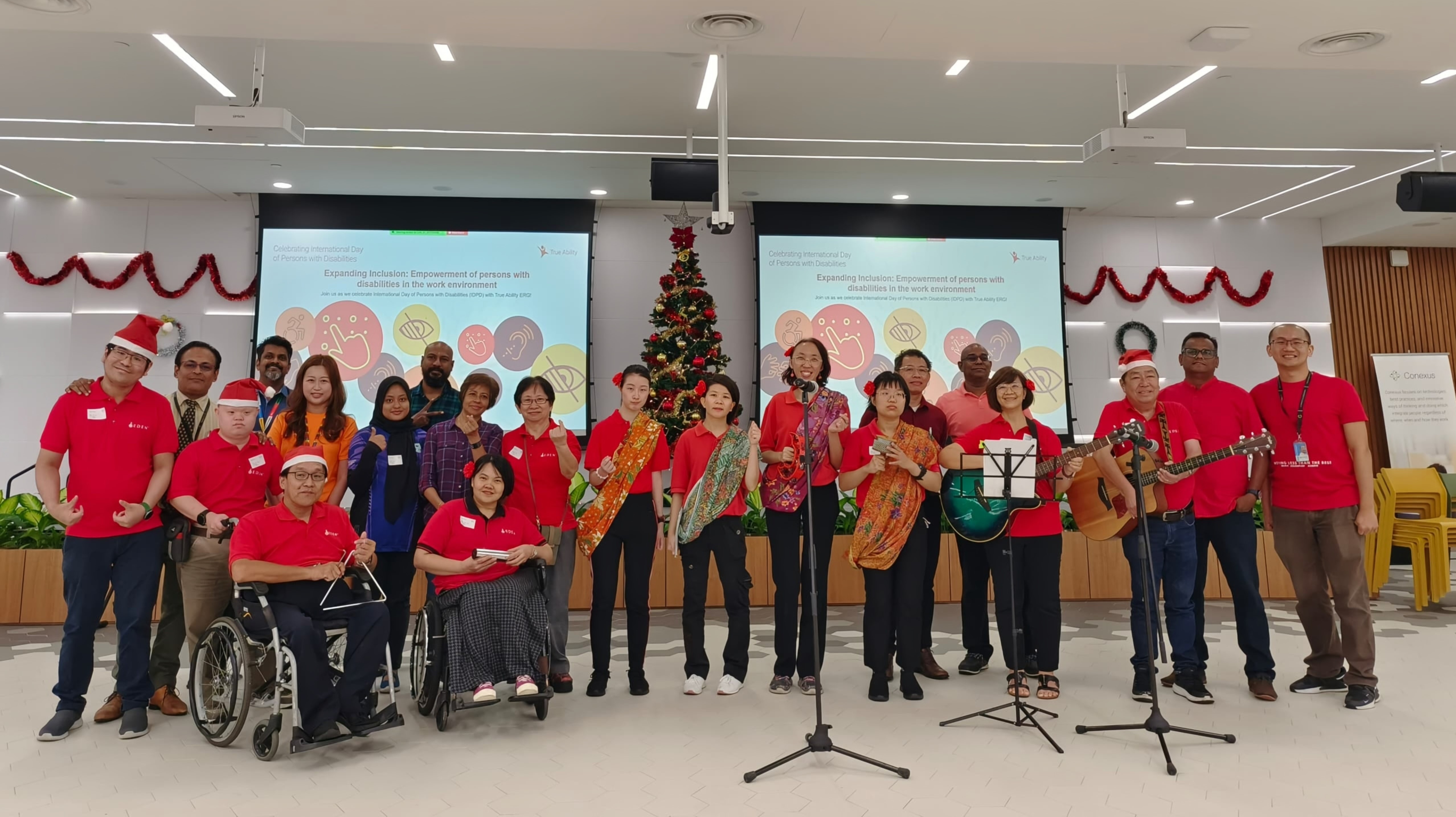 Suthagaran in a group photo at a holiday party with musical instruments