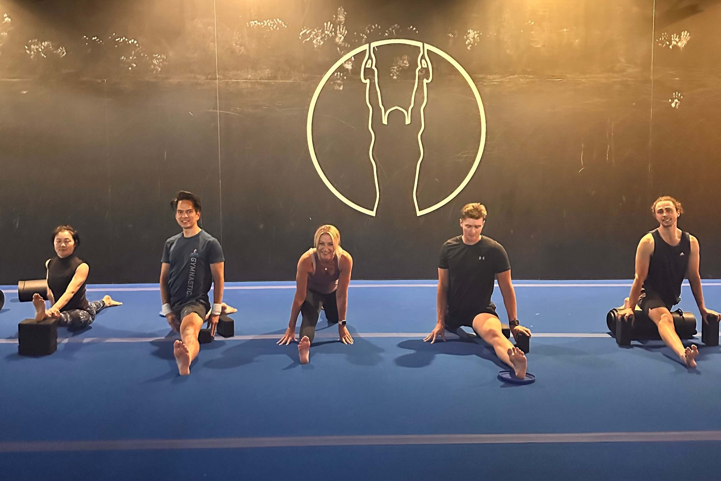 Five people do the middle splits while in a line.