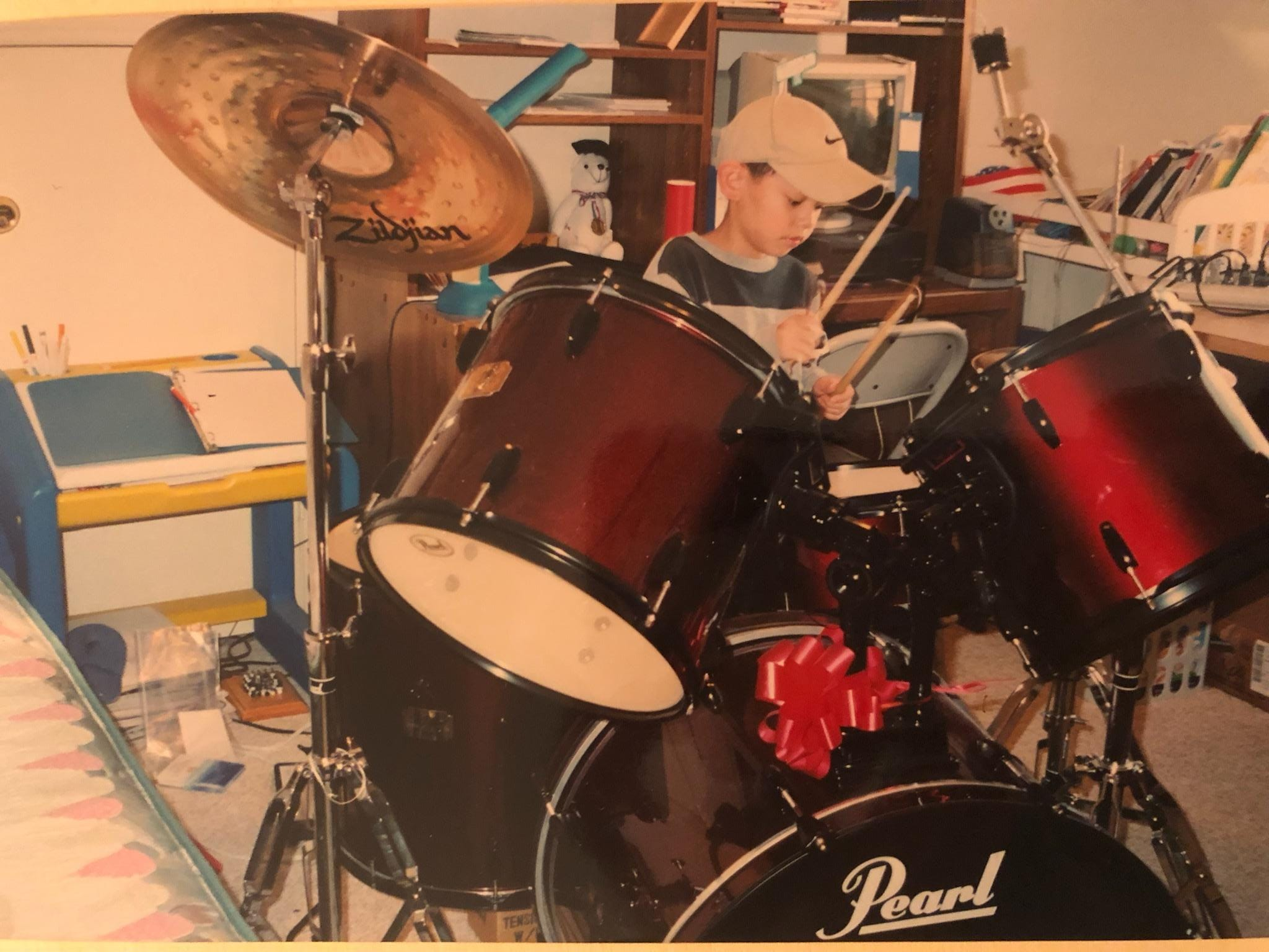 Young YJ plays on a drum set.