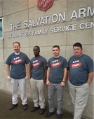 Cuatro hombres se encuentran en un edificio del Ejército de Salvación.