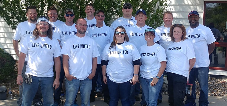 Grupo de hombres y mujeres con camisetas de Live United.