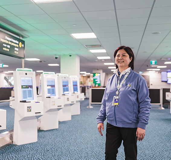 Employée souriante portant un badge debout dans un terminal