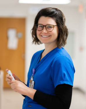 nurse smiling while holding a marker.