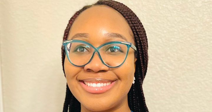 Chidinma smiles in glasses and scrubs.