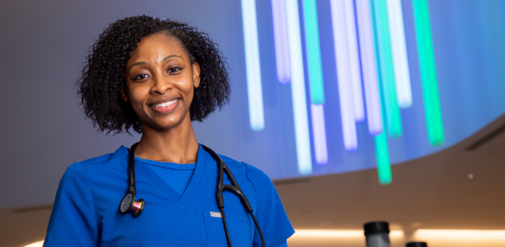 nurse jaysia brown smiling in front of blue and green lights