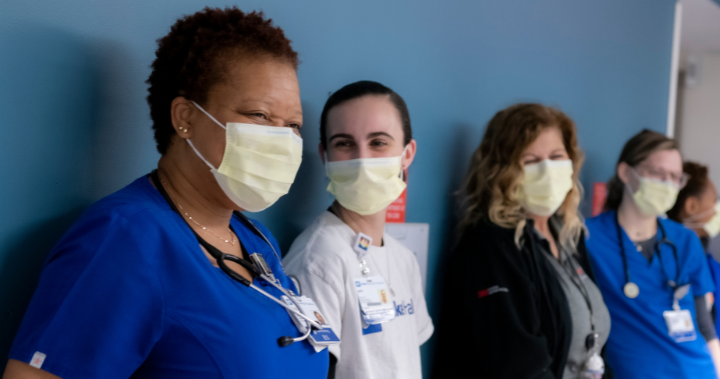 five nursing team members wearing masks and smiling
