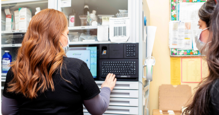 Nurse helps student with machine.