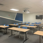 image of classroom with desks, chairs, projector and monitor