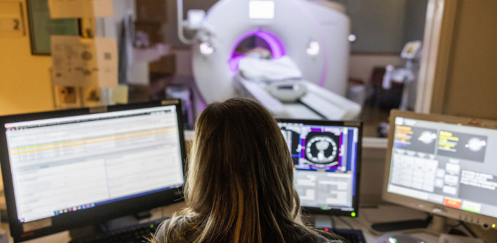 team member monitors an imaging procedure on computer screens.