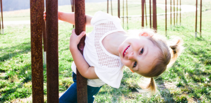 Little girl with pigtails smiling.