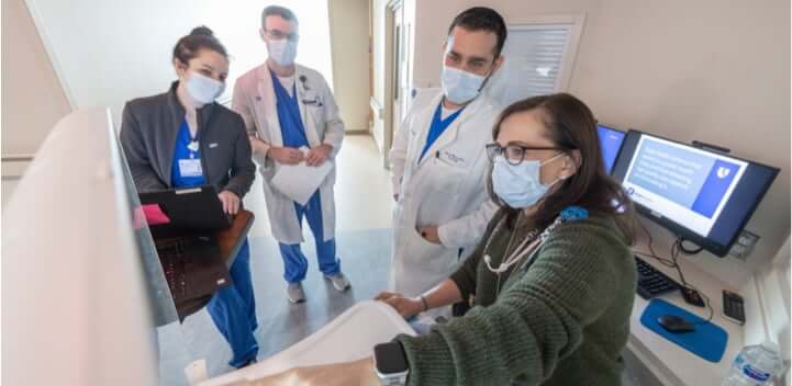 Doctors and nurses reviewing medical information on a screen