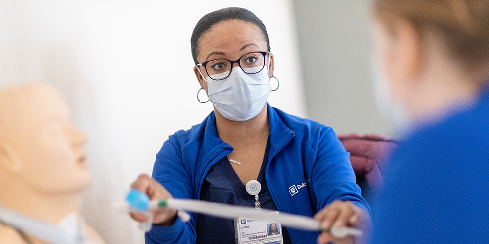 Nurse teaching student a technique on a patient