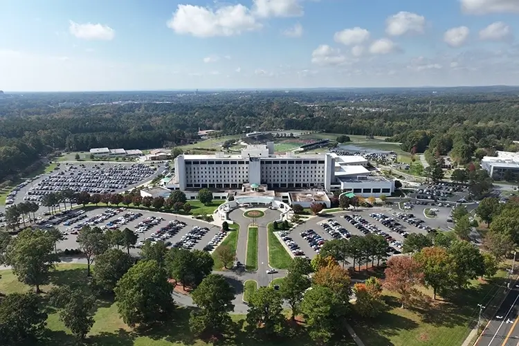 aerial view of a large hospital surrounded by trees and parking lots