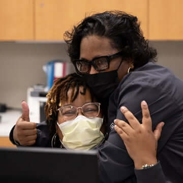 Two female employees embracing one another
