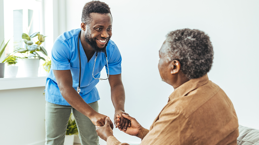 clinician and patient hold hands smiling at each other