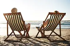 Two people sitting in beach chairs