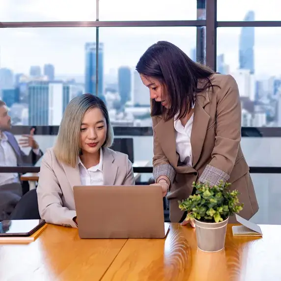 Two people analyzing financial data on a laptop