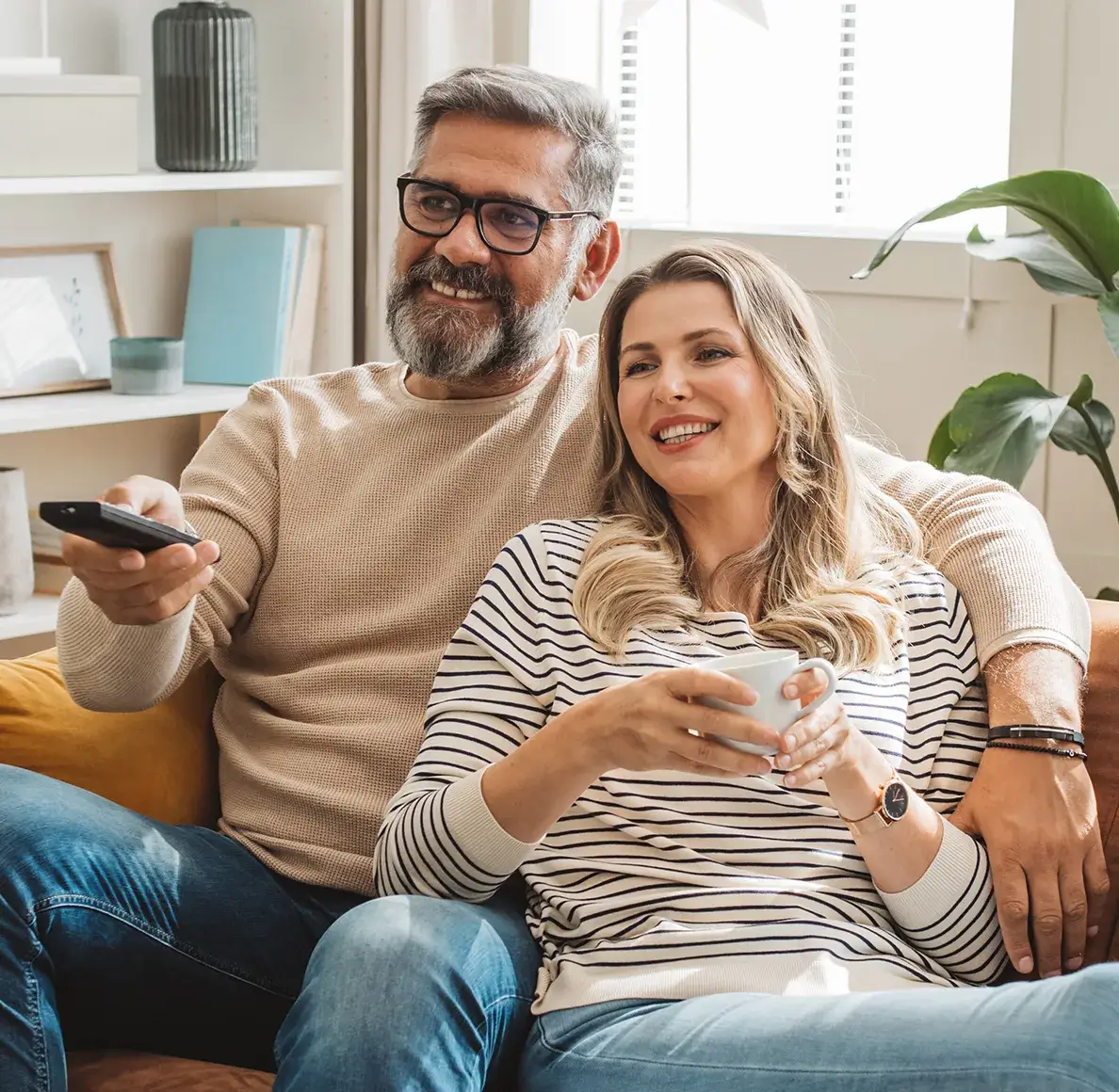couple sitting on couch watching DirecTV