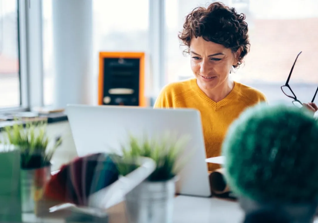 Woman smiling while looking at her computer