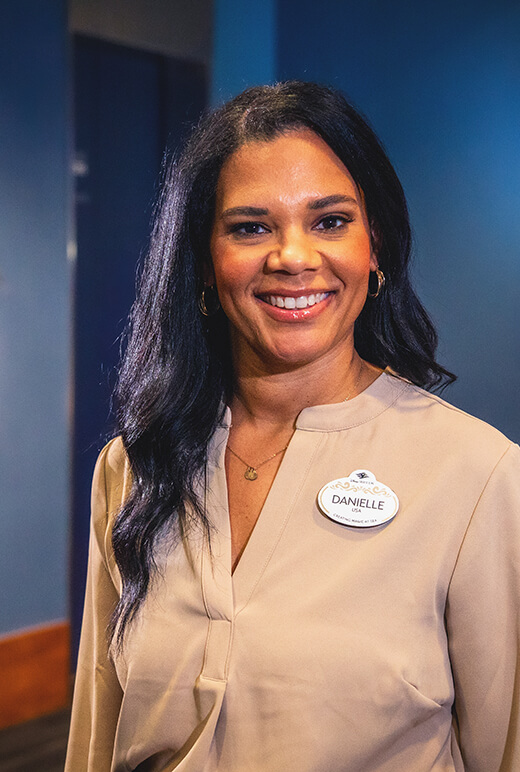 Danielle at the office, wearing office attire and smiling