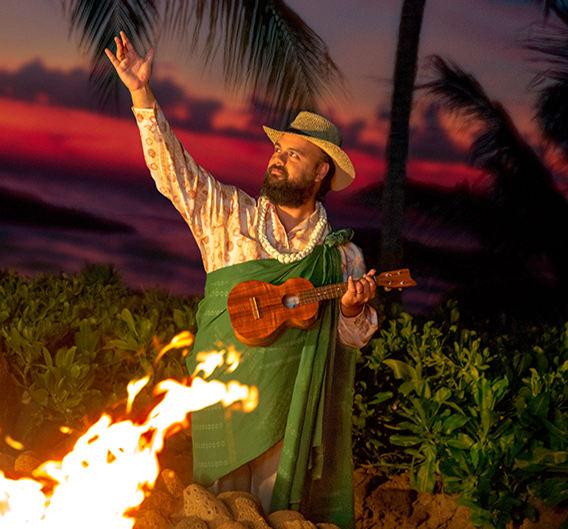 Man playing a ukulele in front of a fire
