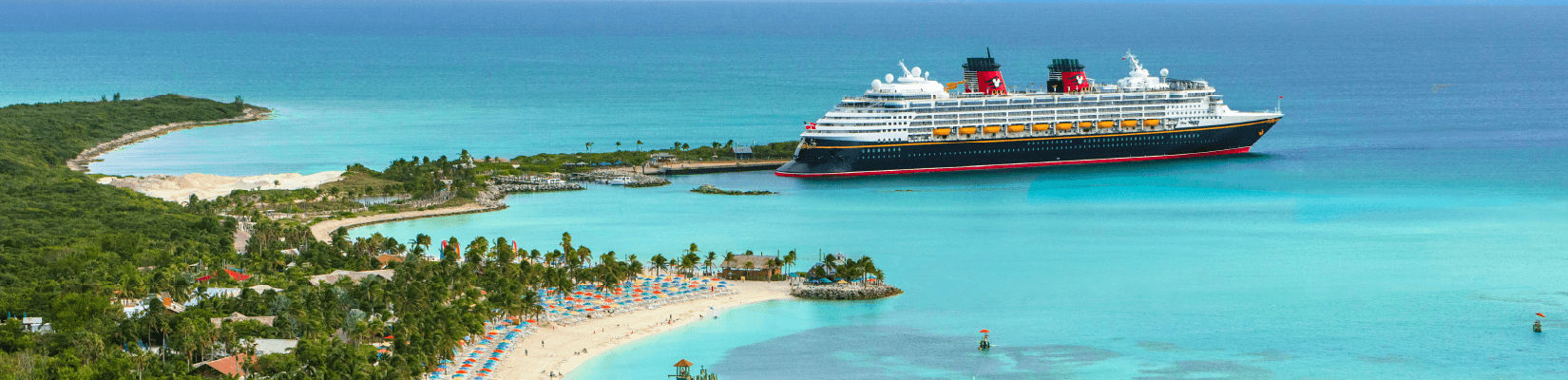 A Disney Cruise Ship pulling into a tropical port.