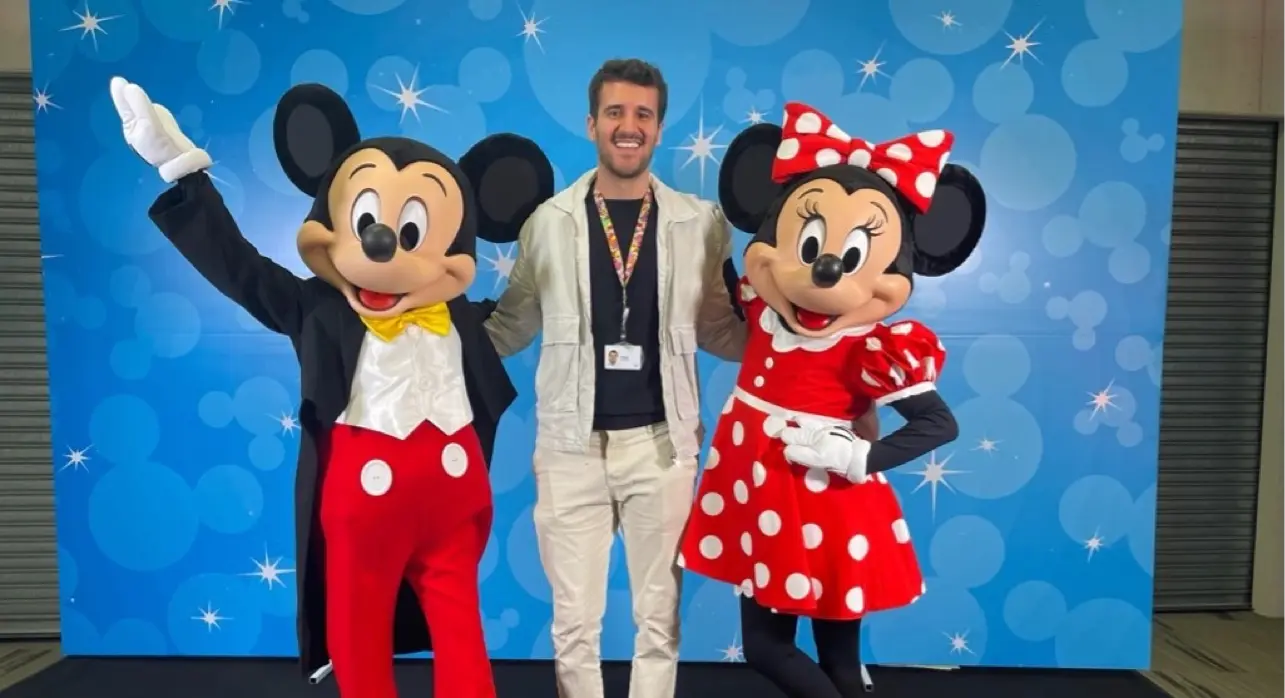 mickey and mini mouse standing next to a trainee