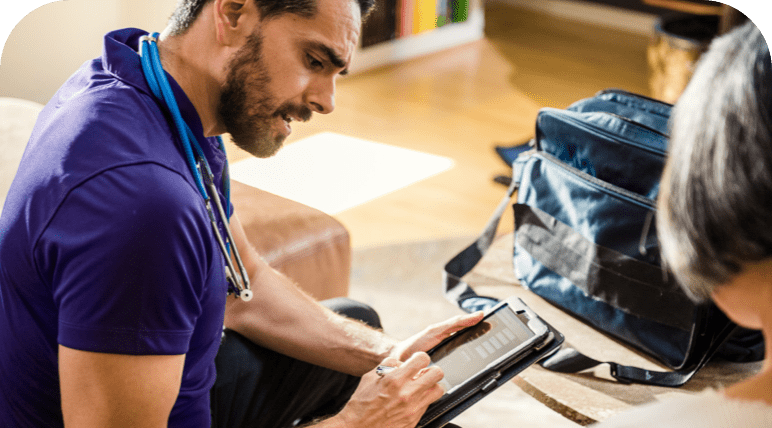 Man staring at a tablet, while talking to a patient