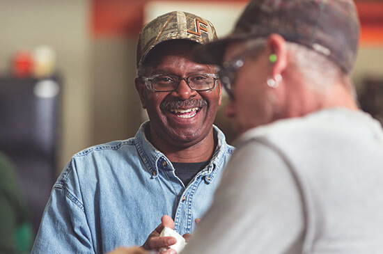 Two men, smiling, in conversation